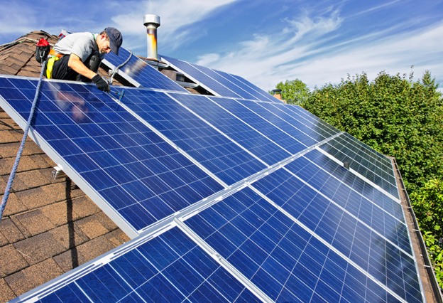 A builder installing solar panels on the roof of a house after discovering whether he could install solar panels by himself.